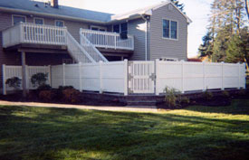 Vinyl fence, stone patio, and stone wall.